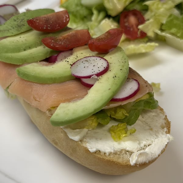 Bistro La Baguette's open-faced salmon sandwich with avocado, radish, and tomato on a baguette.